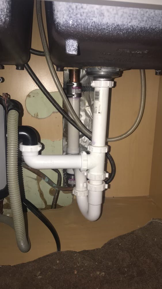 VNew Vinyl pipe under a sink that connects to a garbage disposal unit